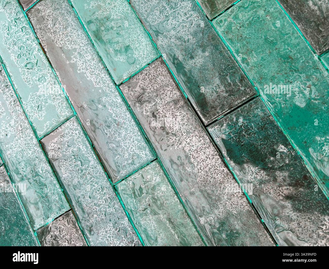Blick von oben auf einen Fliesenboden in Grün- und Grautönen, nass durch den Regen, mit einer diagonalen Struktur. Stockfoto Blick von oben auf einen Fliesenboden in Grün- und Grautönen, nass durch den Regen, mit einer diagonalen Struktur. Stockfoto