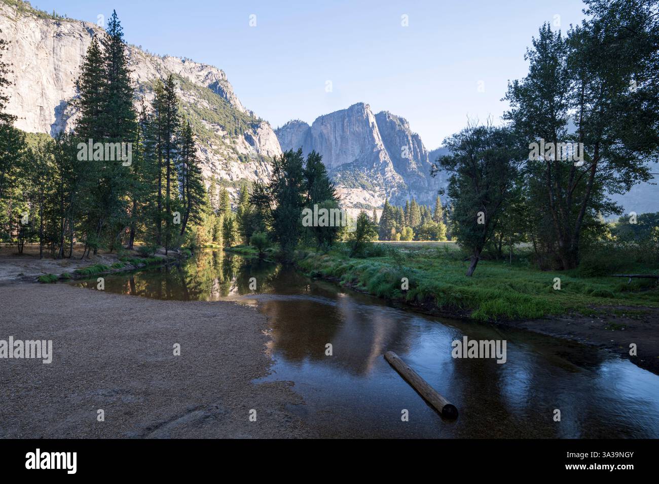 Der Merced River, der an einem ruhigen Sommermorgen durch den Yosemite-Nationalpark fließt. Die majestätischen Granitklippen spiegeln sich im Wasser Stockfoto