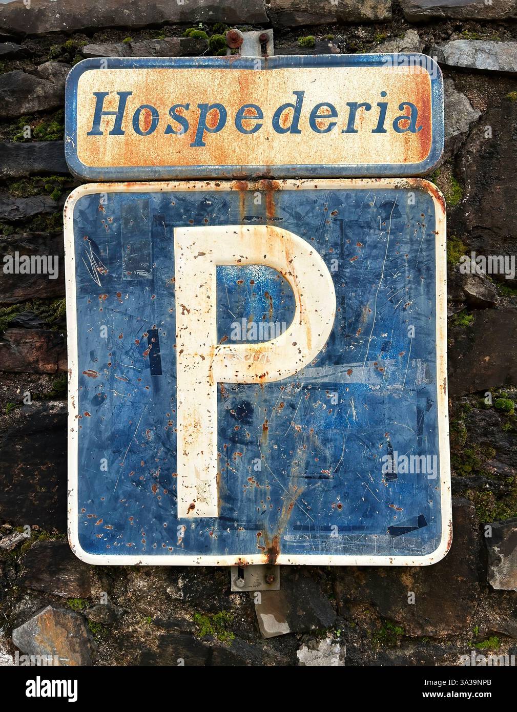 Parkplatzschild in einer spanischen Herberge, mit viel Textur und sehr verwitterungsbedingt. Stockfoto