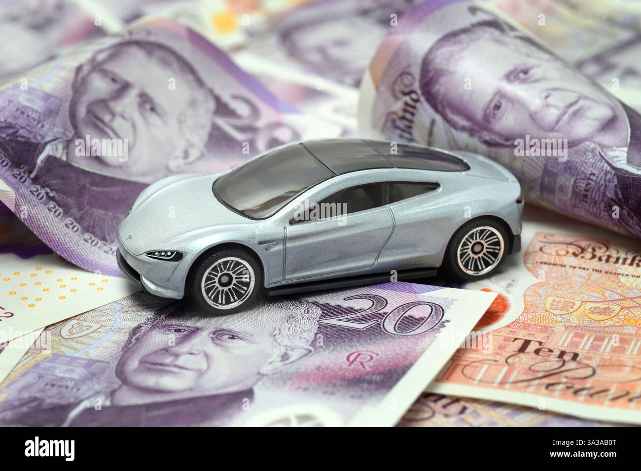 MODELL TESLA ELEKTROAUTO MIT BRITISCHEN BANKNOTEN RE IMPORTE ZÖLLE EXPORTE USW. GROSSBRITANNIEN Stockfoto