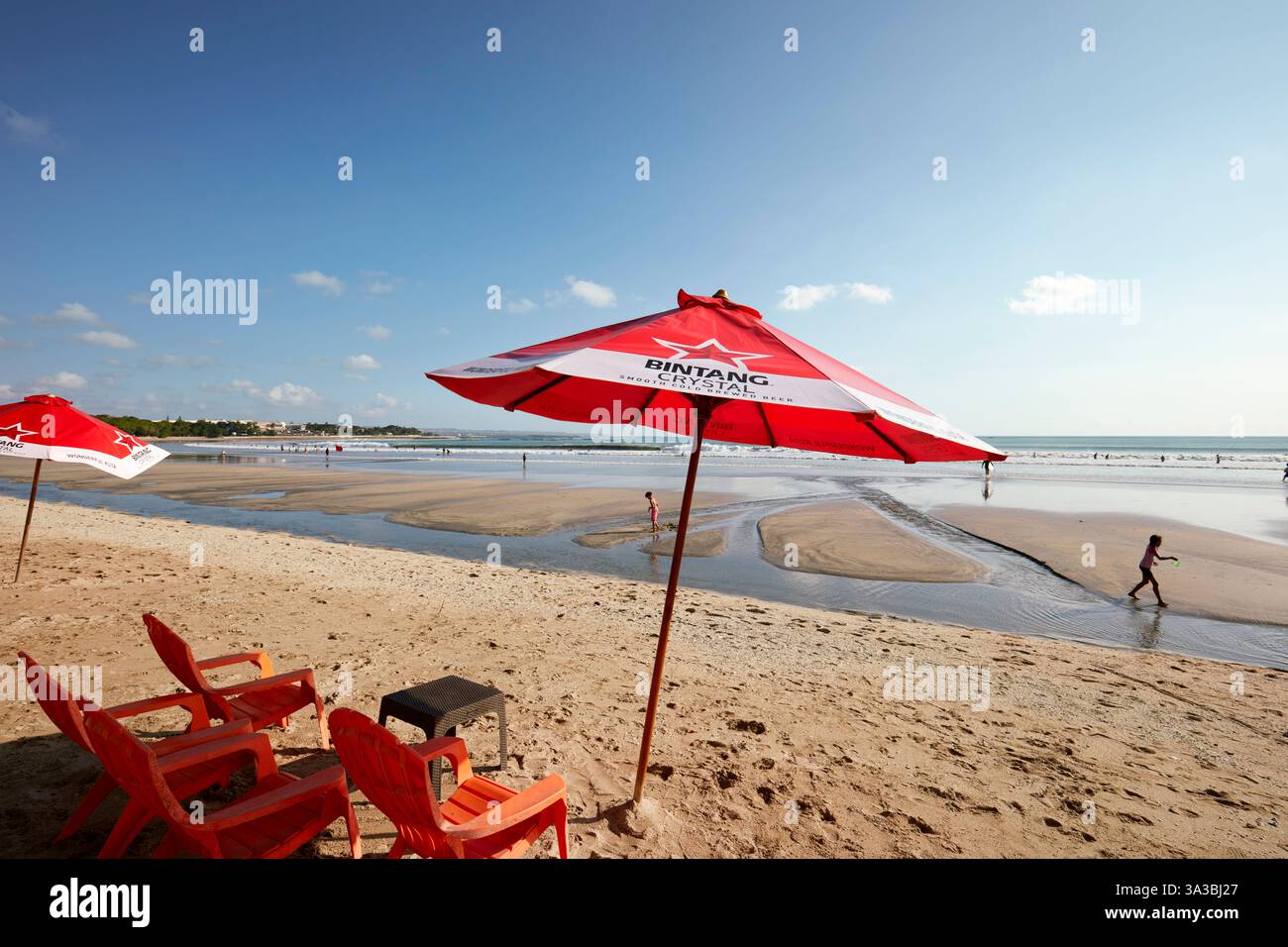 Stühle unter rotem Sonnenschirm am Kuta Beach. Bali, Indonesien. Stockfoto