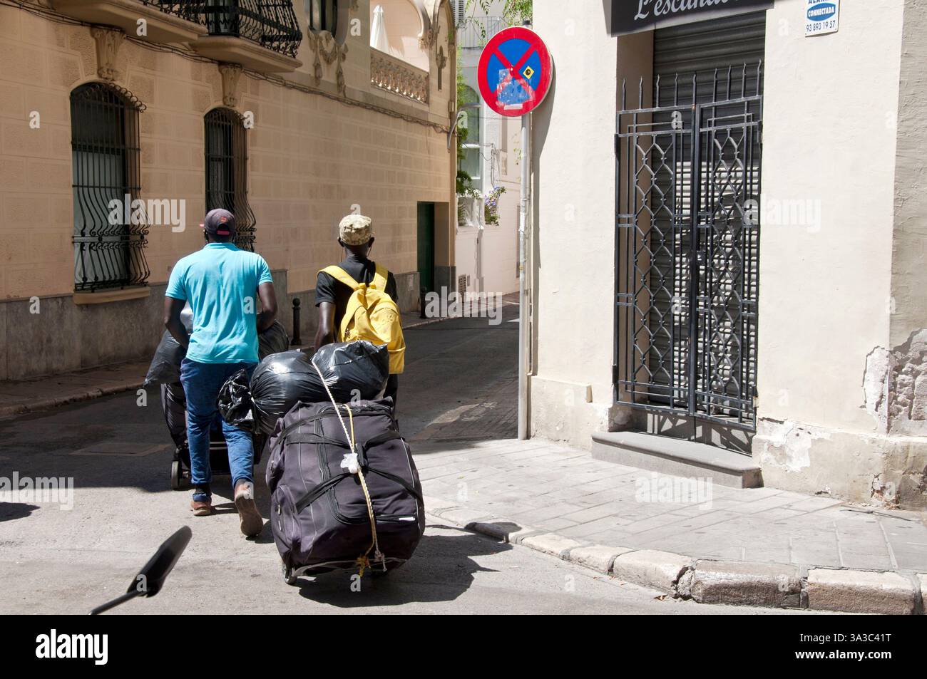Schwarze Männer laden Gegenstände zum Verkauf, Sitges, Garraf Coast, Barcelona, Spanien Stockfoto