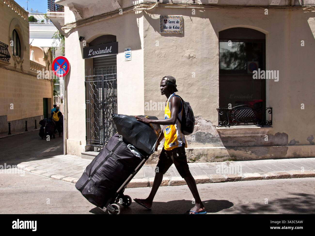 Schwarzer junger Mann, der Gegenstände zum Verkauf lädt, Sitges, Garraf Coast, Barcelona, Spanien Stockfoto