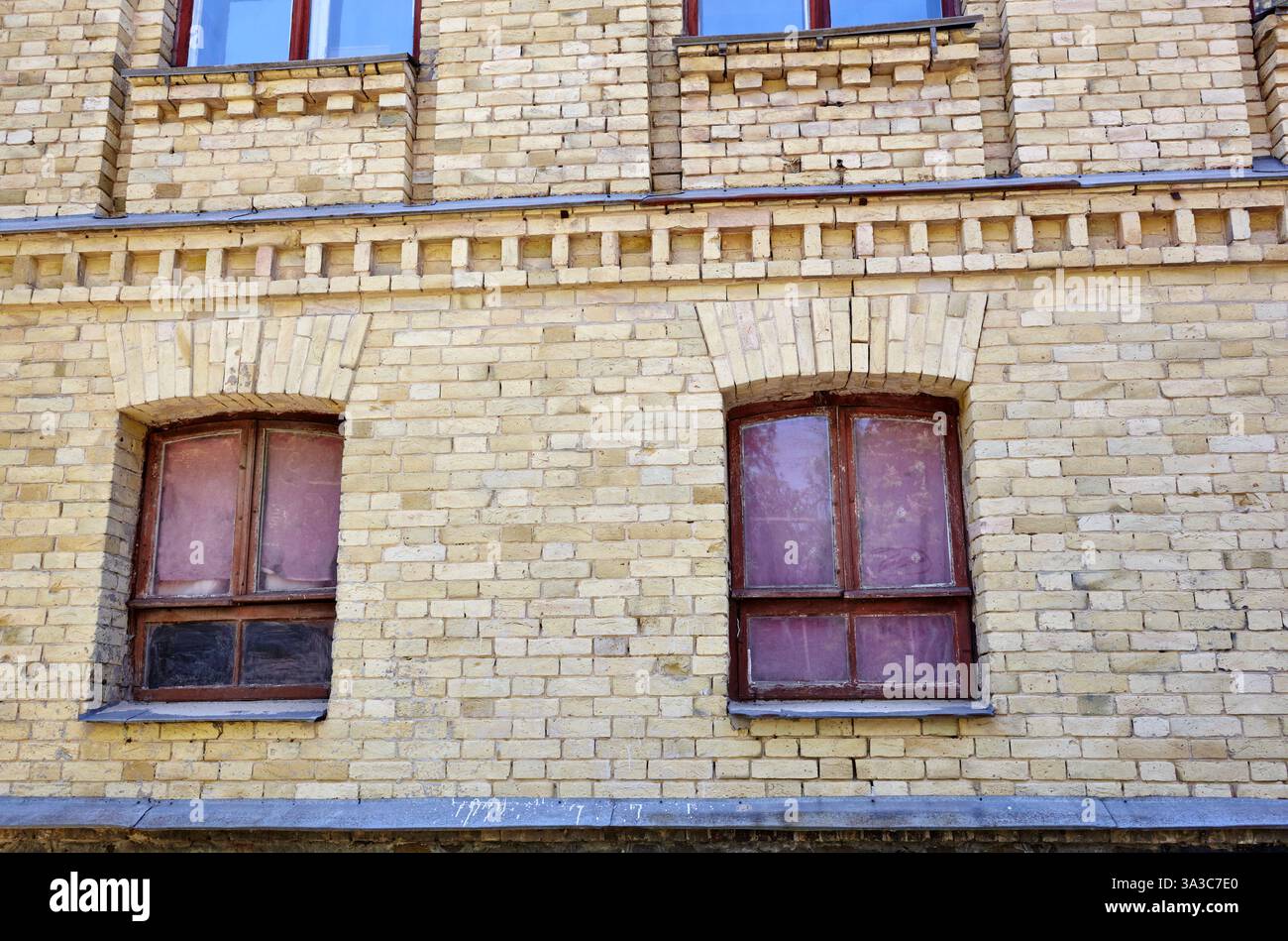 Klassische Backsteinfassade eines Gebäudes aus dem 19. Jahrhundert mit großen Fenstern. Altes Gebäude in Kiew, Ukraine Stockfoto