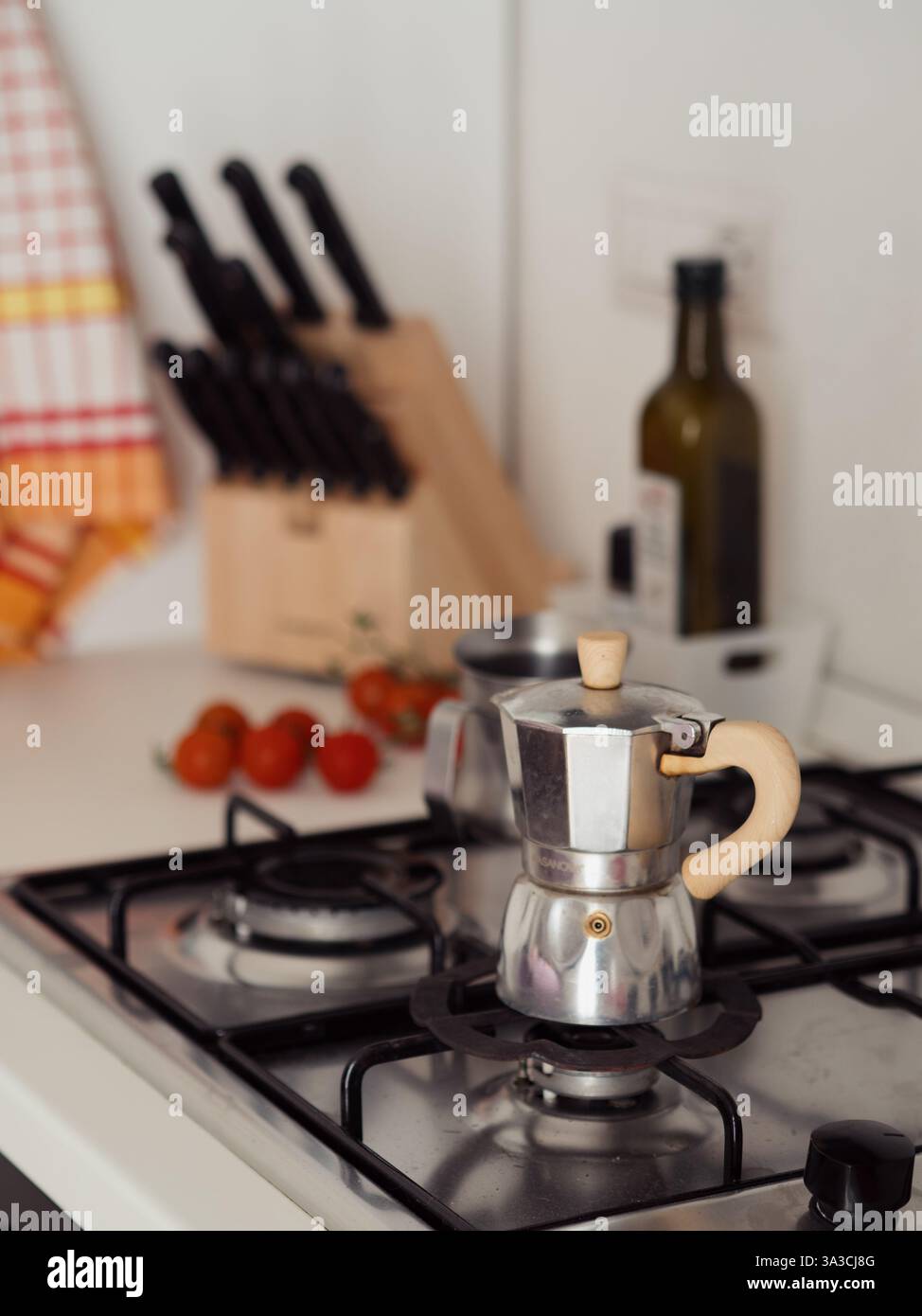 Gemütliche italienische Küche mit Mokakopf und kulinarischen Essentials, vertikaler Blick Stockfoto