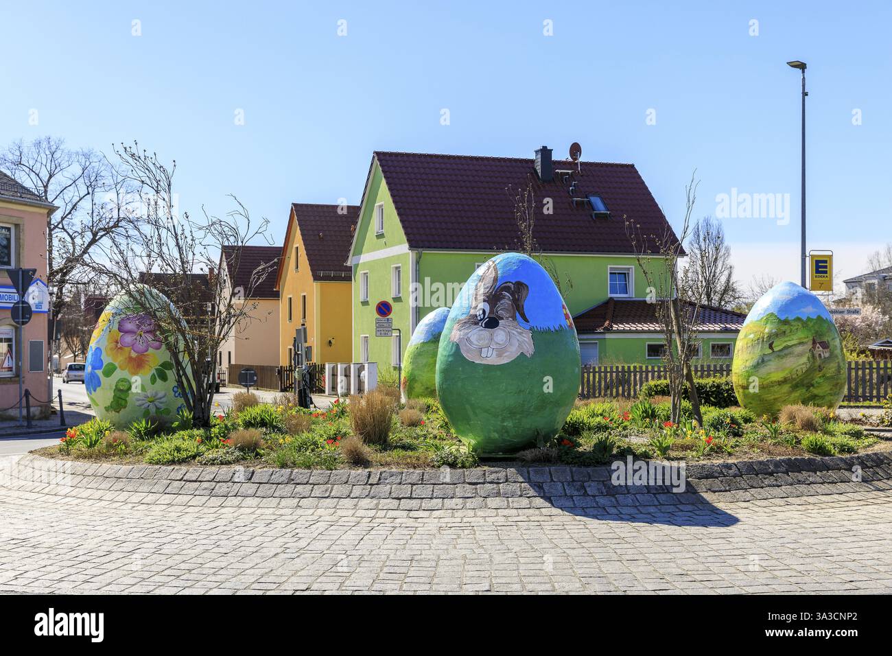 Osterdekoration am Kreisverkehr, im Hintergrund die ehemaligen Stallgebäude an der Hauptstraße, Coswig, Sachsen, Deutschland, Europa Stockfoto