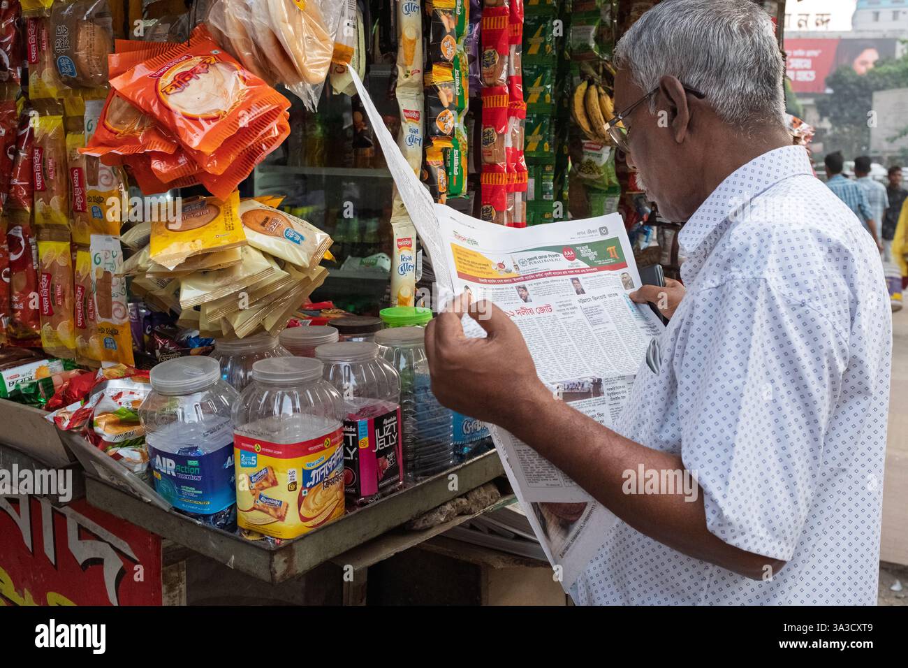 Mann, der die lokalen Nachrichten liest, Dhaka, Bangladesch Stockfoto