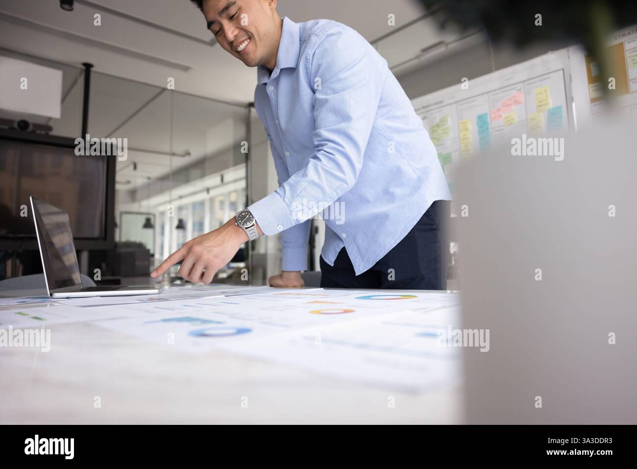 Positiver Analyst für asiatische Geschäftsprojekte, der Marketingforschung unternimmt Stockfoto