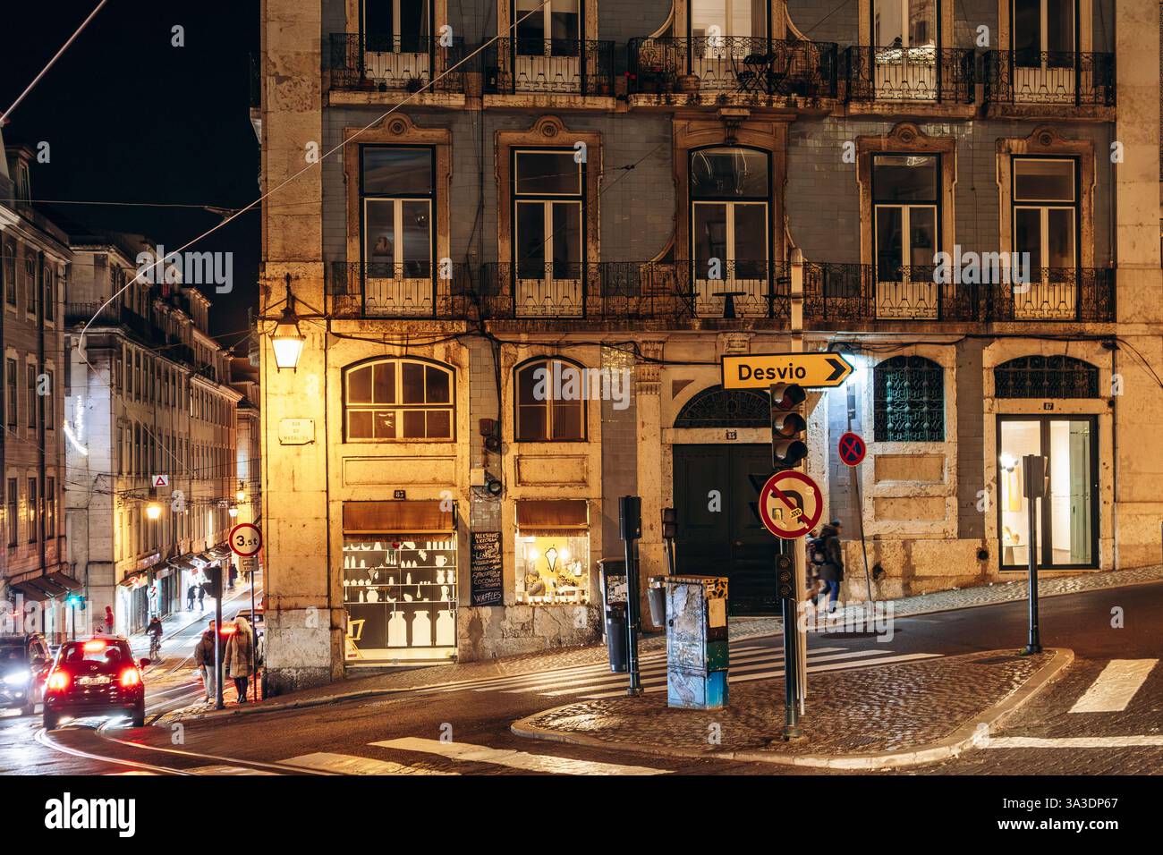 Lissabon, Portugal - 2. Januar 2025: Nächtlicher Blick auf eine Straße im Zentrum von Lissabon, beleuchtet von warmen Stadtlichtern Stockfoto