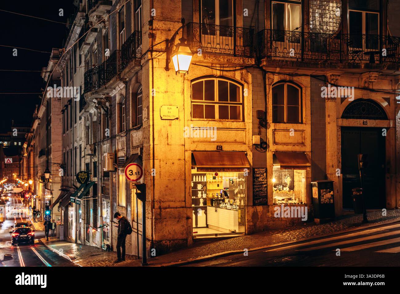 Lissabon, Portugal - 2. Januar 2025: Nächtlicher Blick auf eine Straße im Zentrum von Lissabon, beleuchtet von warmen Stadtlichtern Stockfoto