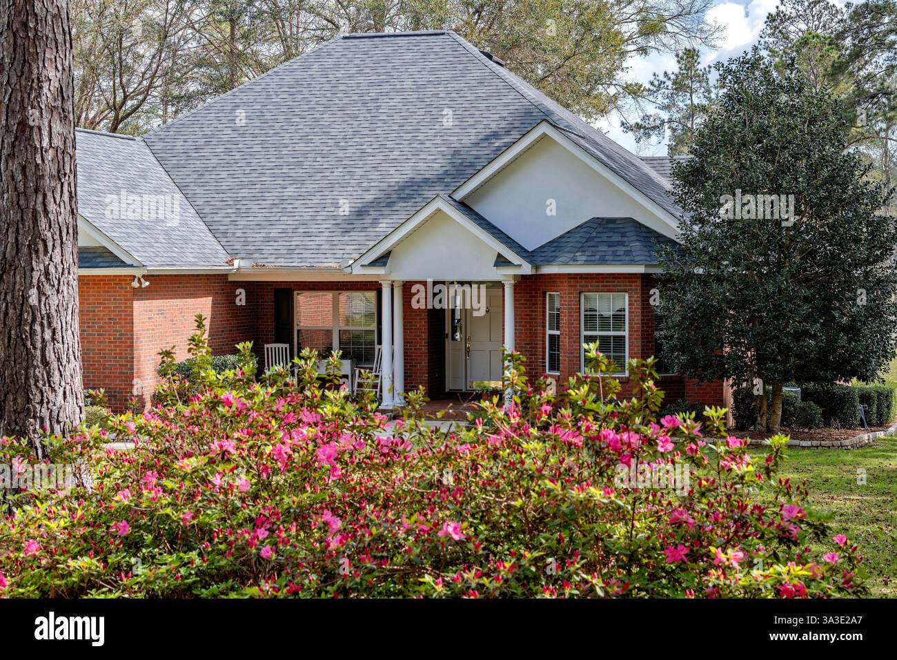 North Florida Wohnhaus aus Kolonialziegel, Frühlingszeit Azaleen in Blüte, schön angelegtes Anwesen. Stockfoto