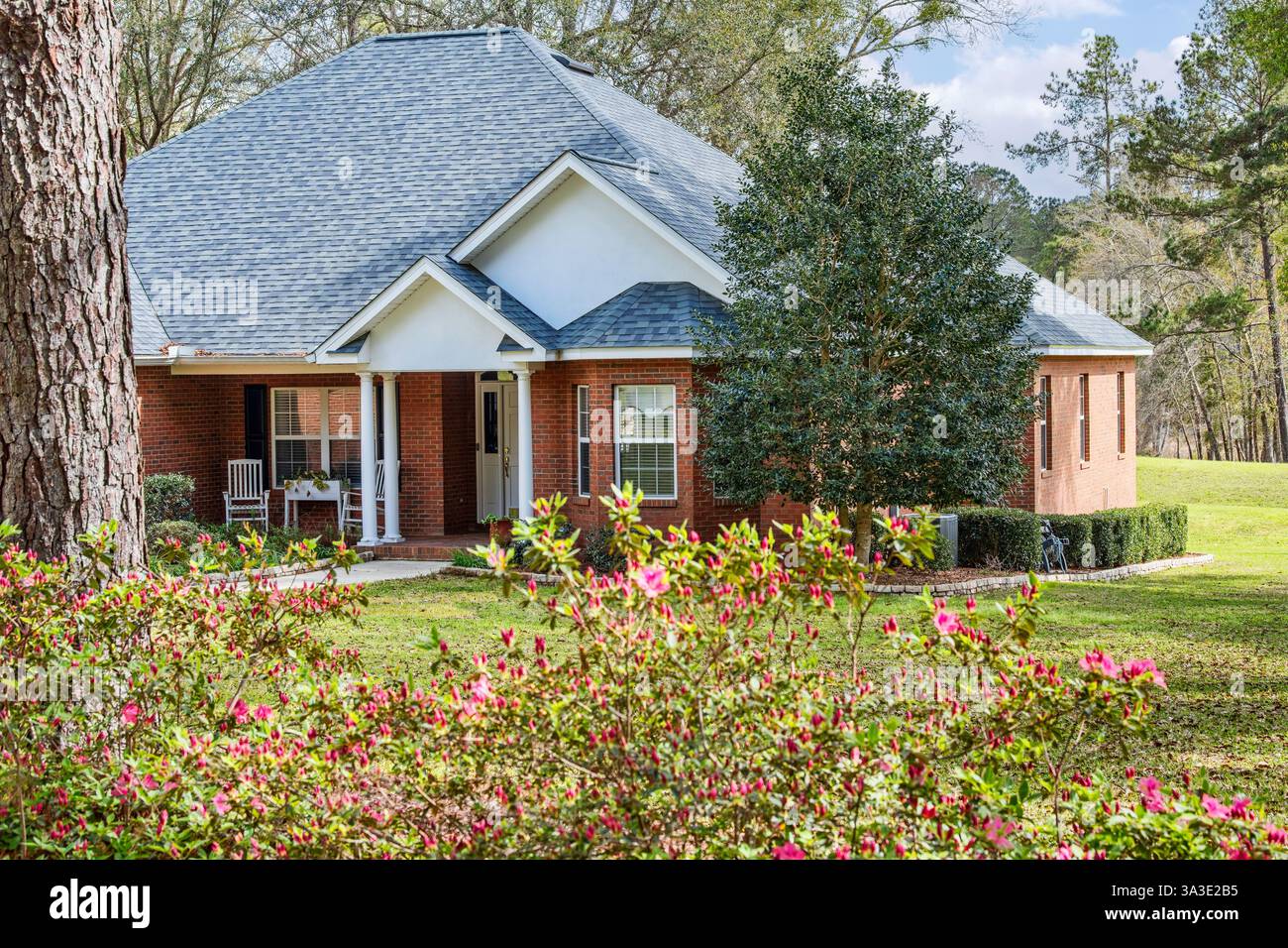 North Florida Wohnhaus aus Kolonialziegel, Frühlingszeit Azaleen in Blüte, schön angelegtes Anwesen. Stockfoto