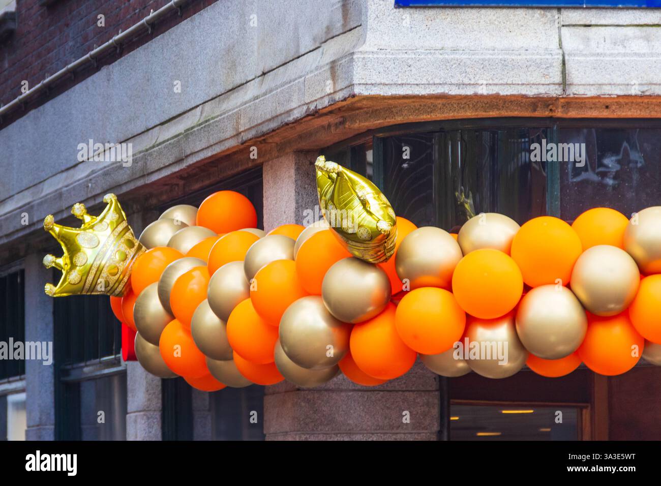 Das Gebäude ist mit orangen Ballons für den Königstag in den Niederlanden dekoriert Stockfoto