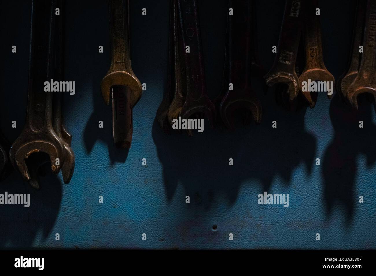 Sauber ausgerichtete Schraubenschlüssel für Schrauben auf einem leuchtend blauen Hintergrund. Ihr metallischer Glanz spiegelt Qualität und Strapazierfähigkeit wider. Ein Bild, das das Wesen festlegt Stockfoto