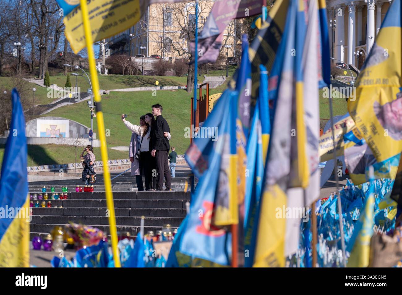 Kiew, Ukraine - 14. März 2025. Leute machen Sylph-Foto. Blick aus der Gedenkstätte zu Ehren ukrainischer und ausländischer Soldaten, die während des Konflikts starben. Stockfoto