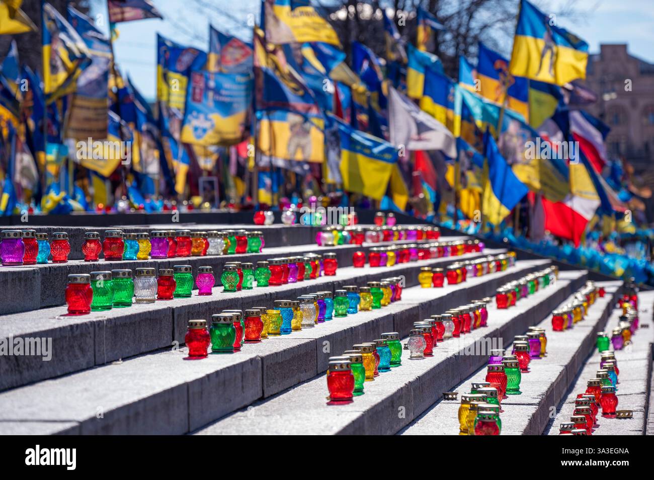 Kiew, Ukraine - 14. März 2025. Eine lebendige Gedenkstätte mit Kerzen und Fahnen erinnert an die Soldaten, die im andauernden Konflikt verloren gegangen sind. Stockfoto
