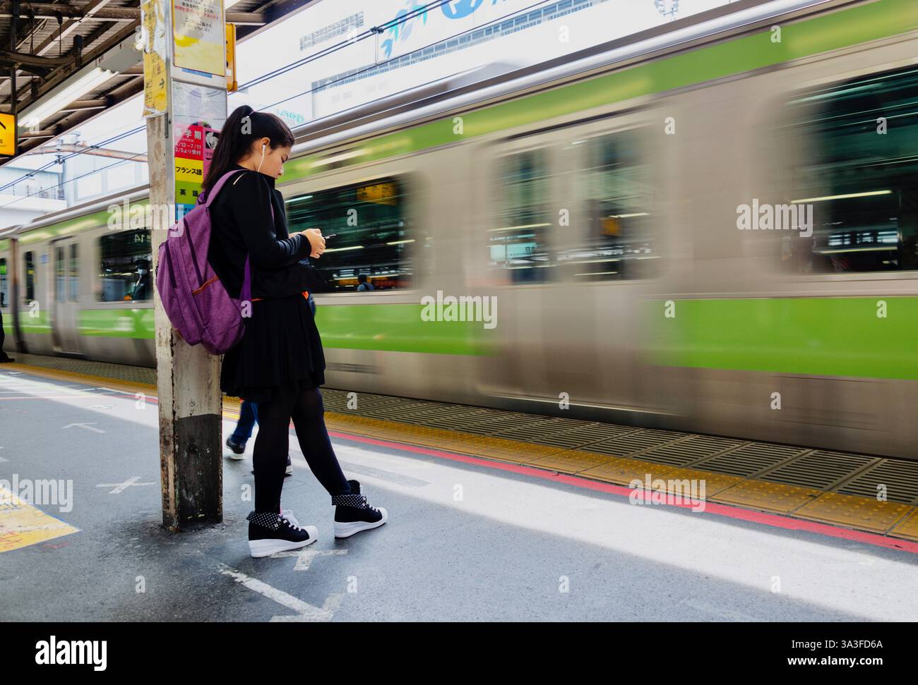 Ein Passagier wartet am Bahnhof Shinjuku in Tokio auf einen Zug der Yamanote-Linie. Stockfoto