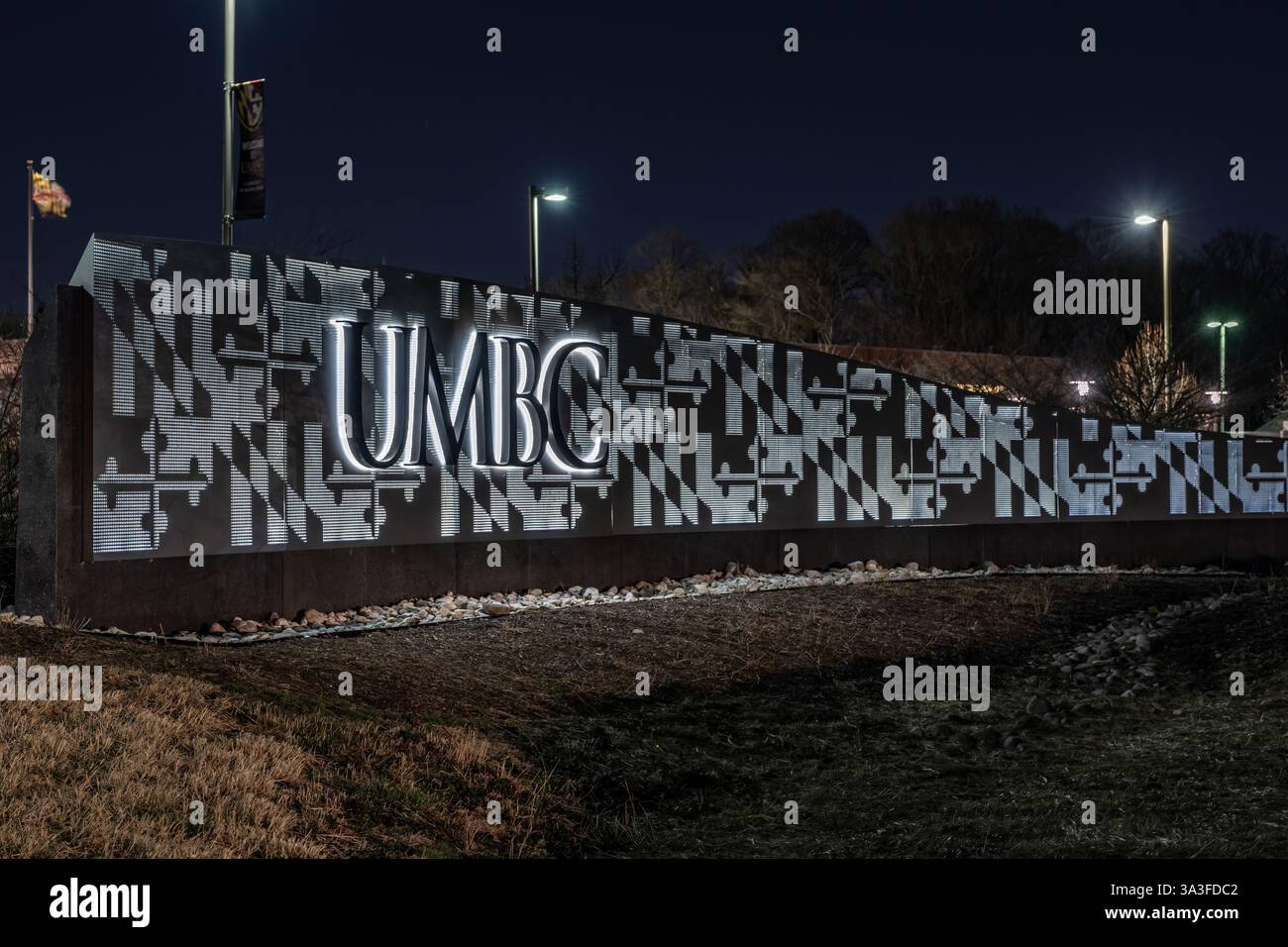 Baltimore, MD, USA - 8. März 2025: Nachtfoto des beleuchteten UMBC-Schilds auf dem Campus der University of Maryland Baltimore County. Stockfoto