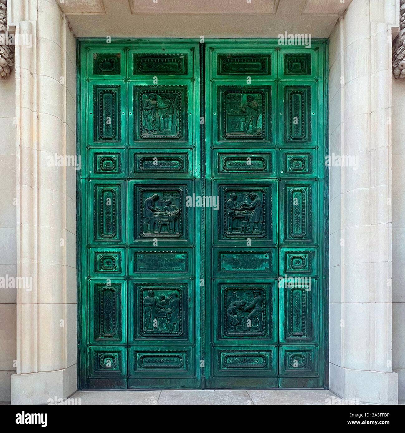Große, grün patinierte Bronzetüren mit komplizierten Flachreliefplatten, die historische und künstlerische Szenen darstellen, eingerahmt von Kalksteinarchitektur. Stockfoto