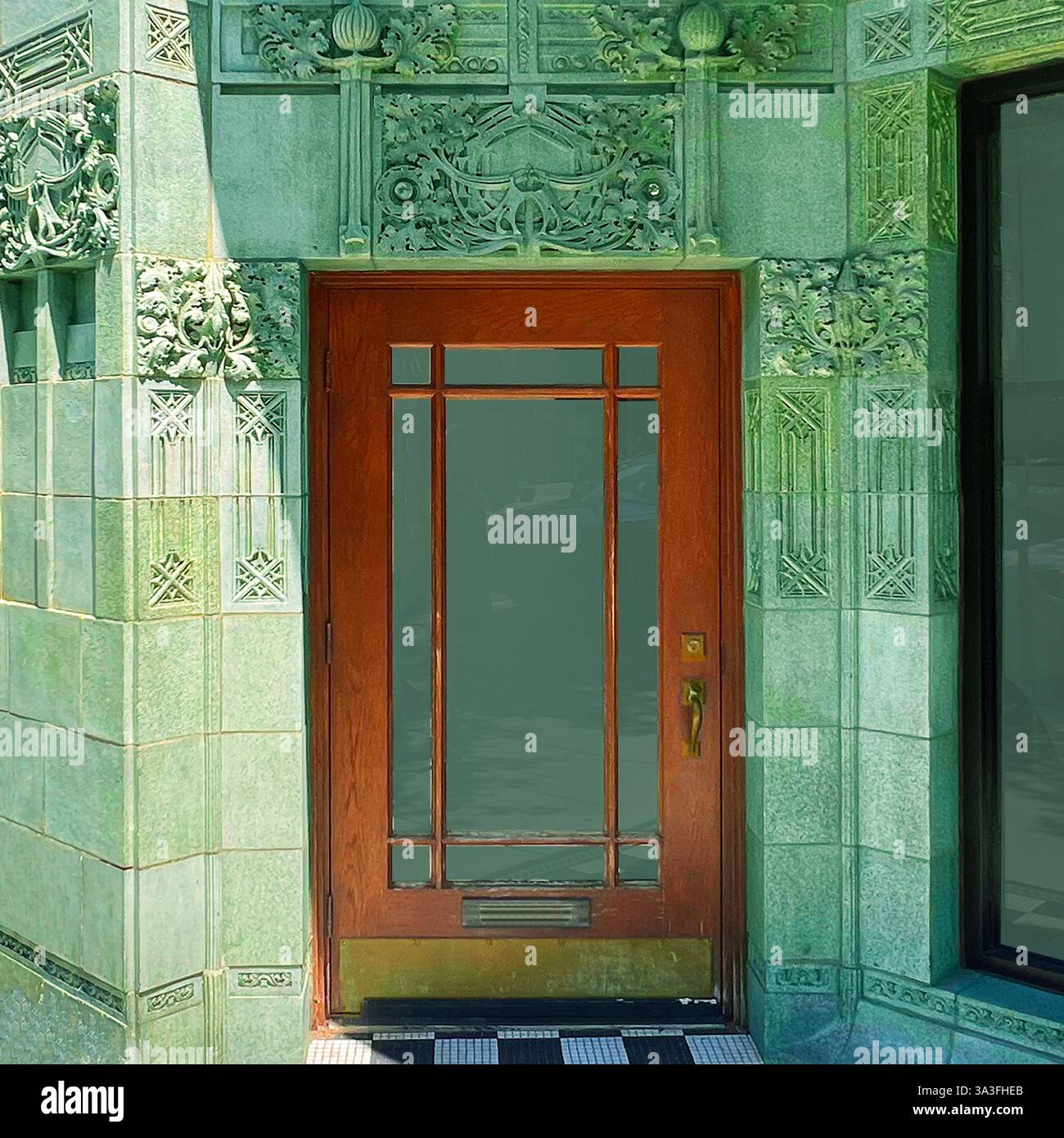 Ein wunderschöner Eingang in einer kunstvollen, grün gefliesten Fassade eines historischen Chicagoer Gebäudes. - Smartphone-aufgenommenes Stockfoto