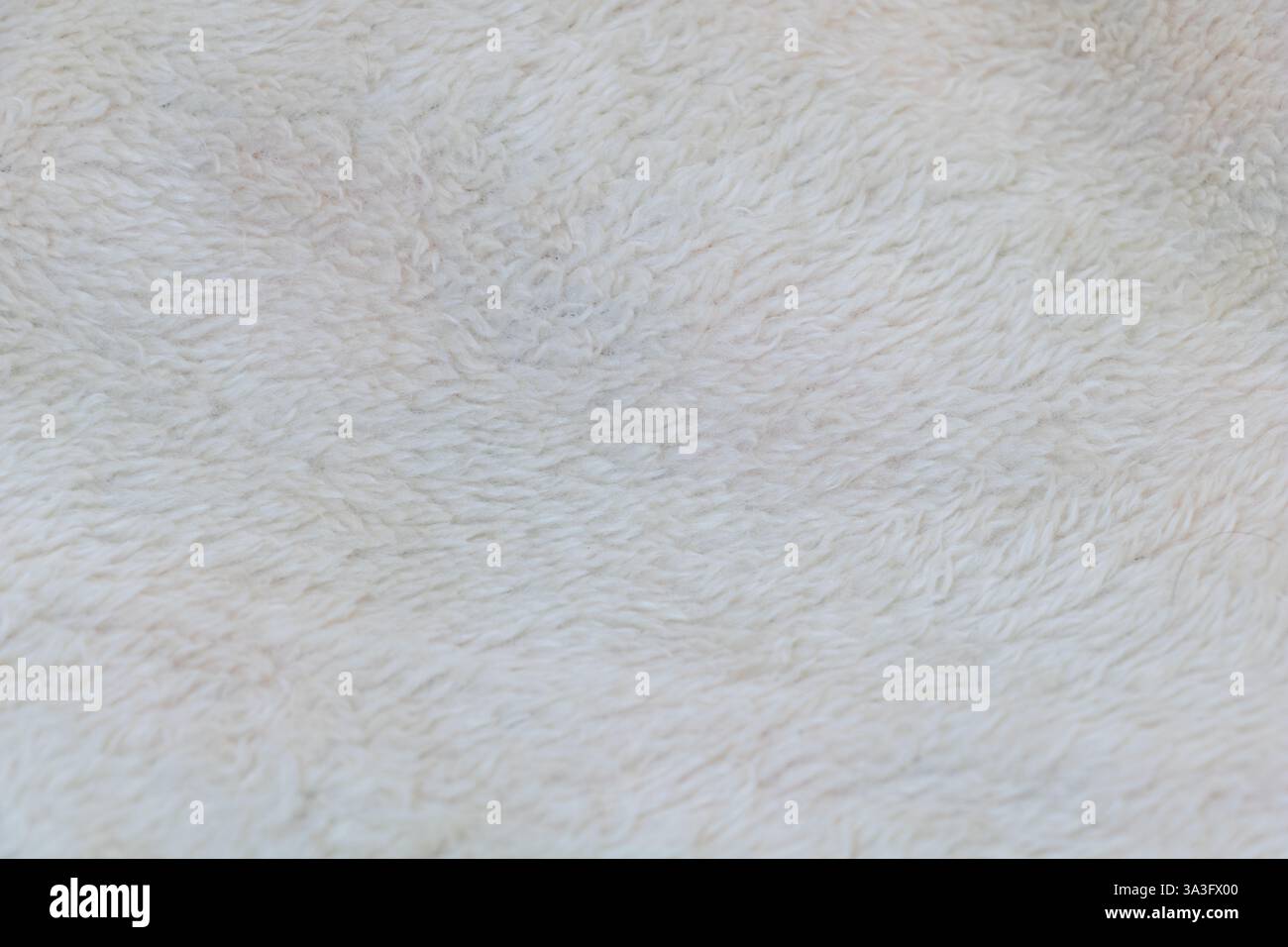 Weißer Plüschhintergrund, Wollstoff. Weiße Felloberfläche mit weicher und flauschiger Oberfläche. Stockfoto