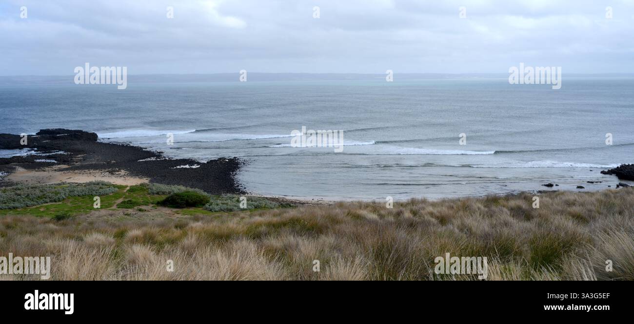 Die Wellen ziehen sich über die Bucht von Cowrie auf Phillip Island Victoria Australien vom Point zum Strand Stockfoto