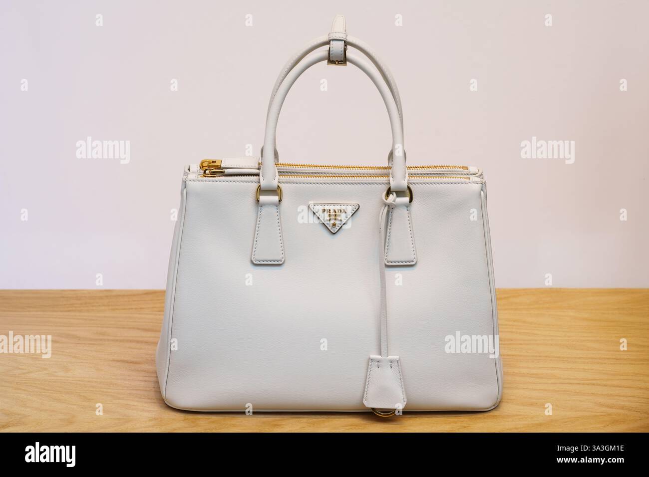 Mailand, Italien - 24.04.2024: Elegante weiße Prada Handtasche auf Holzoberfläche Stockfoto
