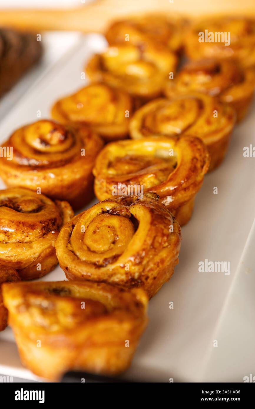 Frisch gebackenes Gebäck, süße Brötchen, die auf dem Buffet-Tisch in einer gemütlichen Bäckerei oder einem Café serviert werden, um Frühstück, Brunch und Dessertliebhaber mit süßen Speisen zu genießen Stockfoto