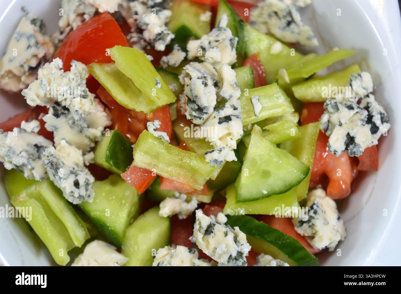 Blauschimmelkäse, Blauschimmelsalat mit grünen Chilischeiben, Tomaten und Gurken, Käse mit essbaren Formen, die blau-grün bilden Stockfoto