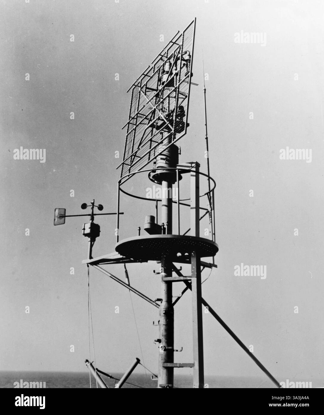 WWII RADAR – SC war ein in den USA hergestelltes Luft- und Oberflächenradar, das während des Zweiten Weltkriegs von der United States Navy eingesetzt wurde. - Navy-Escort-Träger USS Long Island (AVG-1) mit Radarantenne SC und Anemometer, 13. März 1942. Stockfoto