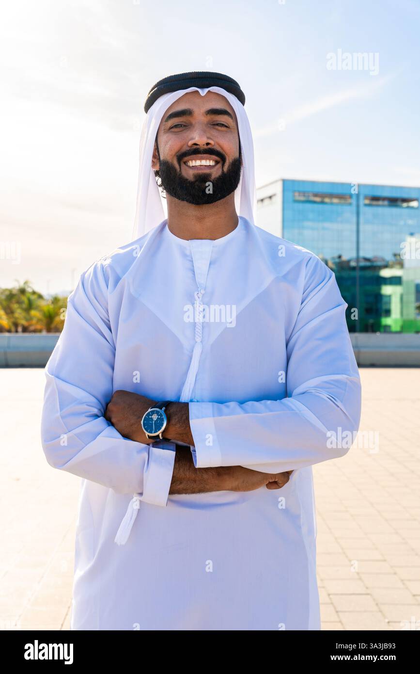Traditioneller arabischer Mann, der im Freien emirat Kandura trägt - hübsches männliches Geschäftsmann-Porträt aus dem Nahen Osten in der Stadt Stockfoto