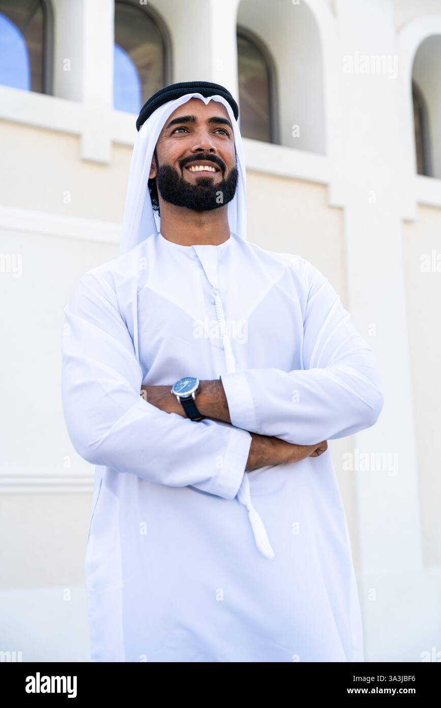 Traditioneller arabischer Mann, der im Freien emirat Kandura trägt - hübsches männliches Geschäftsmann-Porträt aus dem Nahen Osten in der Stadt Stockfoto