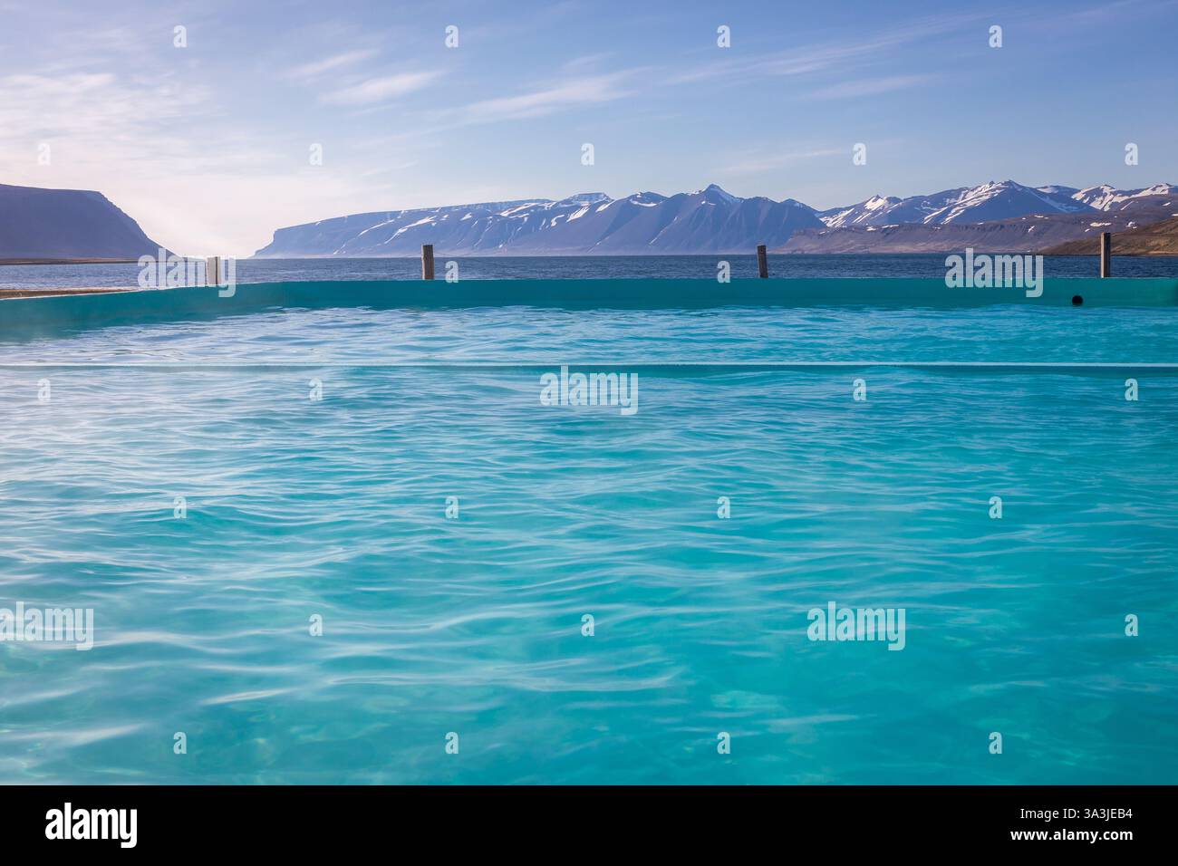 Reykjafjardarlaug heißer geothermischer Pool mit türkisfarbenem Wasser, Westjorden Blick auf die schneebedeckten Berge und eine Bucht, Island, keine Leute. Stockfoto