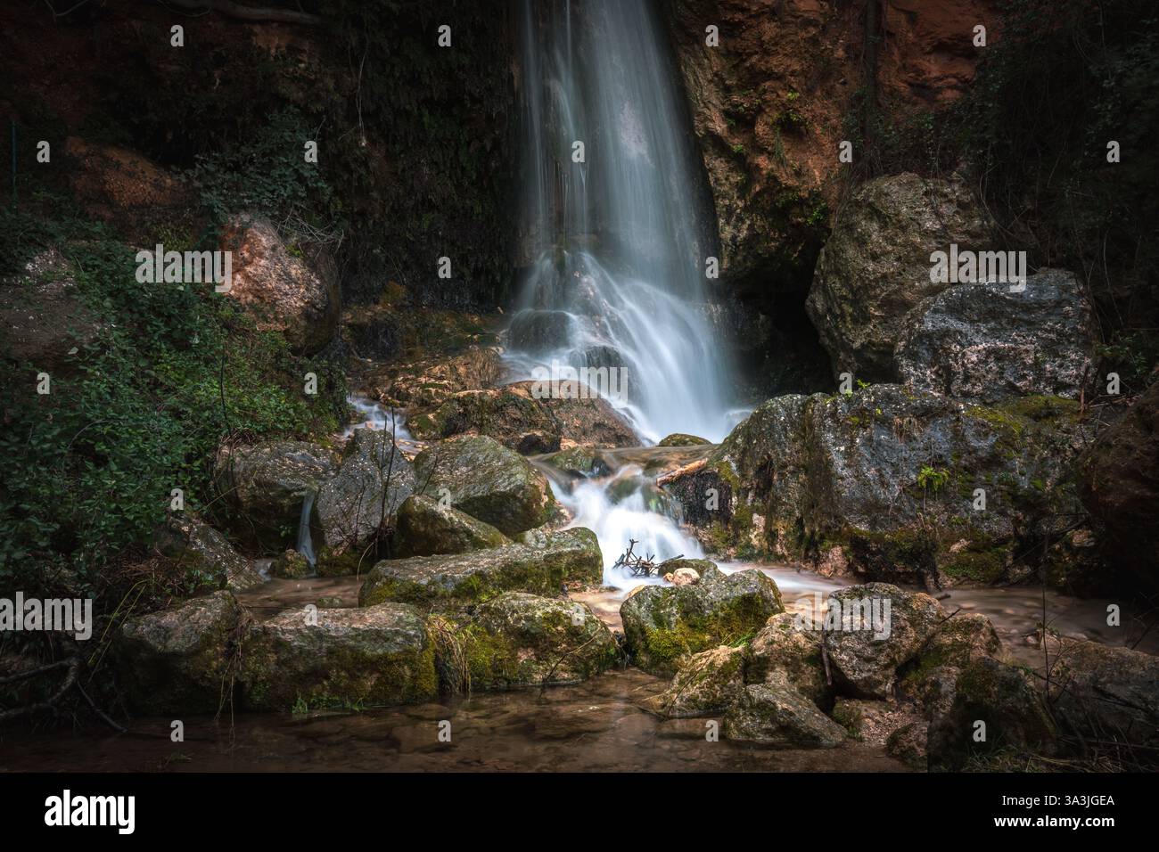 Wasserfall am Fluss Benizar in der Nähe der Mühle in der Stadt Benizar in Moratalla, Region Murcia, Spanien, an einem bewölkten Wintertag. Stockfoto