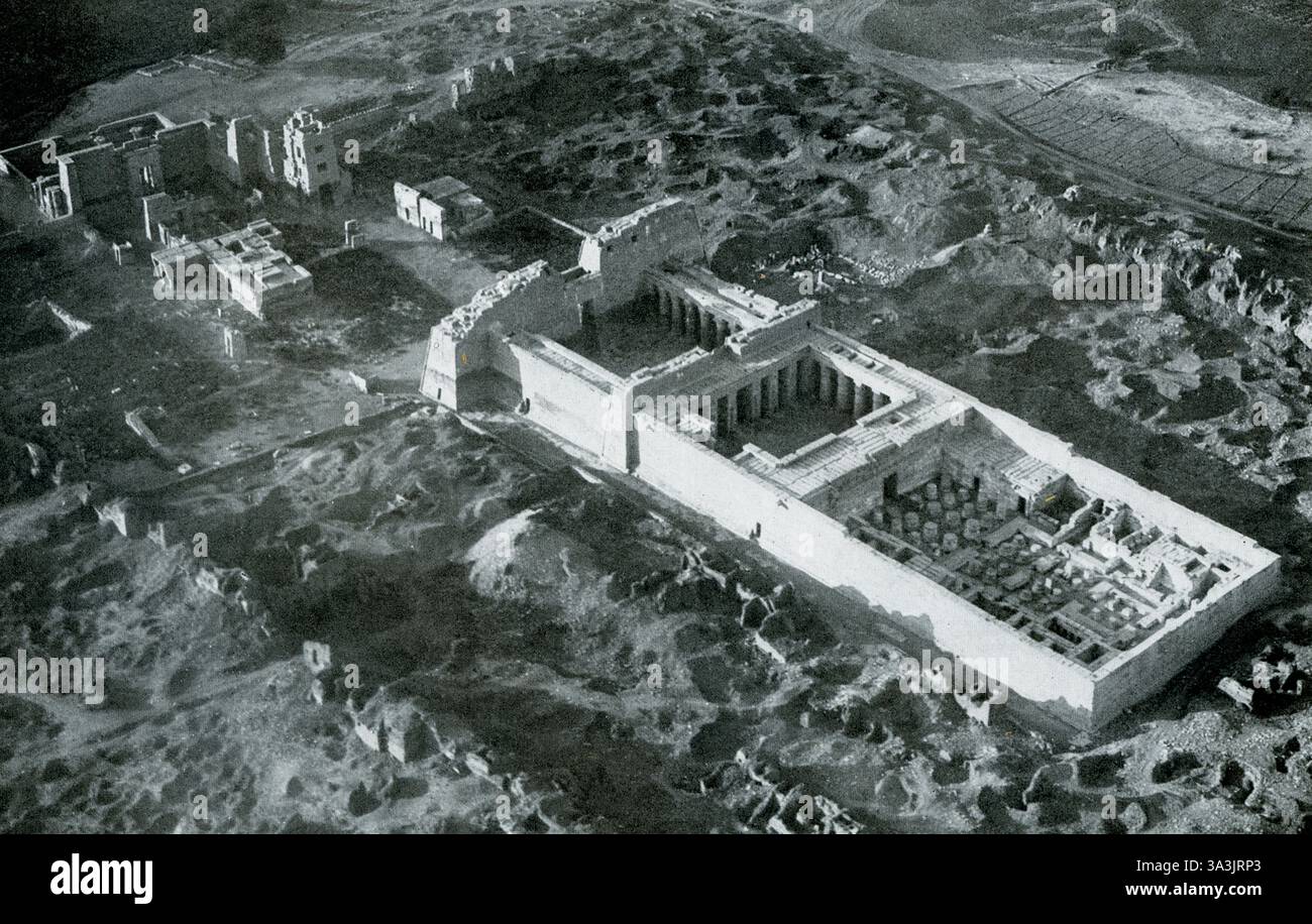 Dieses Foto aus dem Jahr 1925 zeigt eine Luftaufnahme des Tempels und Palastes in Medinet-Habu in Theben. Medinet Habu ist ein archäologischer Ort am Fuße des Theban Hills am Westufer des Nils gegenüber der modernen Stadt Luxor. Es war einer der ersten Orte in Theben, die eng mit dem lokalen Gott Amun verbunden waren. Auf seinem Höhepunkt beherbergte Medinat Habu Tempel, Lagerräume, Werkstätten, Verwaltungsgebäude, einen königlichen Palast und Unterkünfte für Priester und Beamte. Es war jahrhundertelang das Zentrum des Wirtschaftslebens Theben. Stockfoto