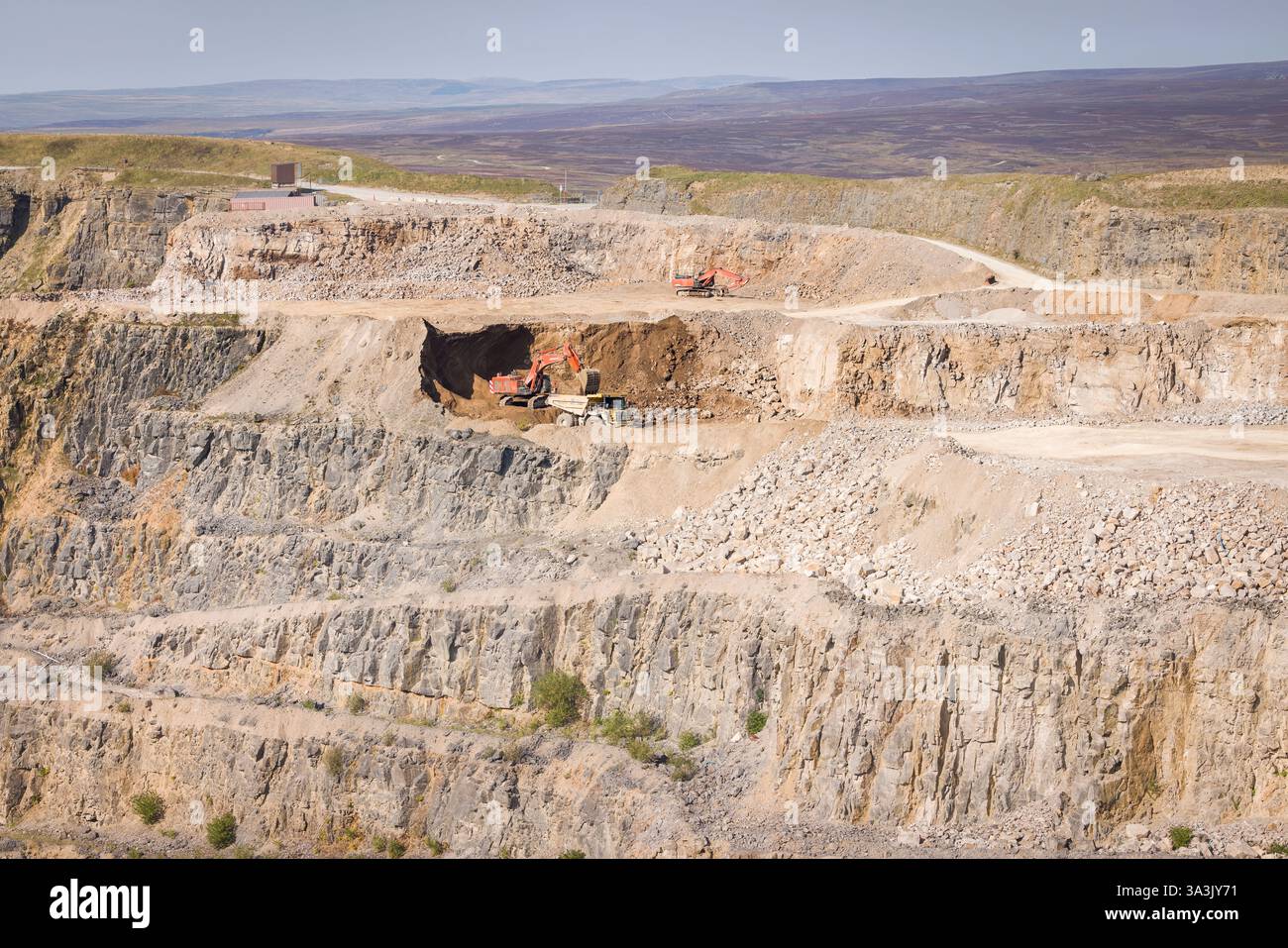 Harrogate, Großbritannien - 19. September 2024. Bagger und Transportfahrzeuge arbeiten in einem Steinbruch. Coldstones Quarry, Pateley Bridge, Yorkshire Dales, Großbritannien Stockfoto