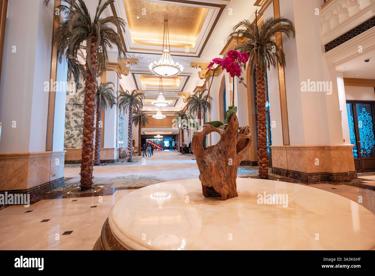 19. Januar 2025, Emirates Palace Hotel, Abu Dhabi, Vereinigte Arabische Emirate: Elegante Hotellobby mit Orchideen, Palmen und exquisiten Kronleuchtern Stockfoto