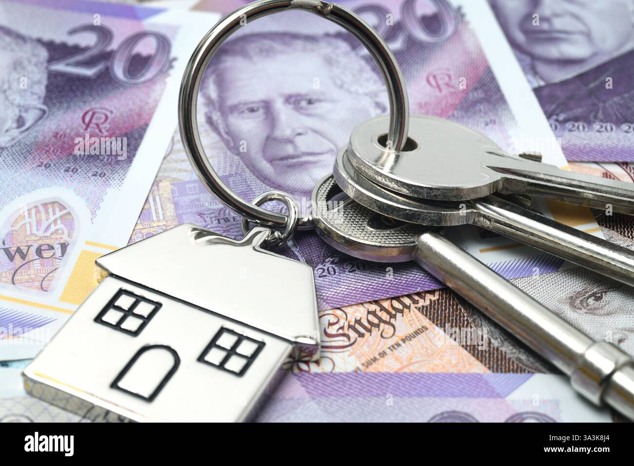 HAUSSCHLÜSSEL MIT HAUSSCHLÜSSELANHÄNGER UND BANKNOTEN RE HYPOTHEKEN EINLAGEN HAUSKÄUFER HAUSVERKÄUFE KREDITE USW. GROSSBRITANNIEN Stockfoto