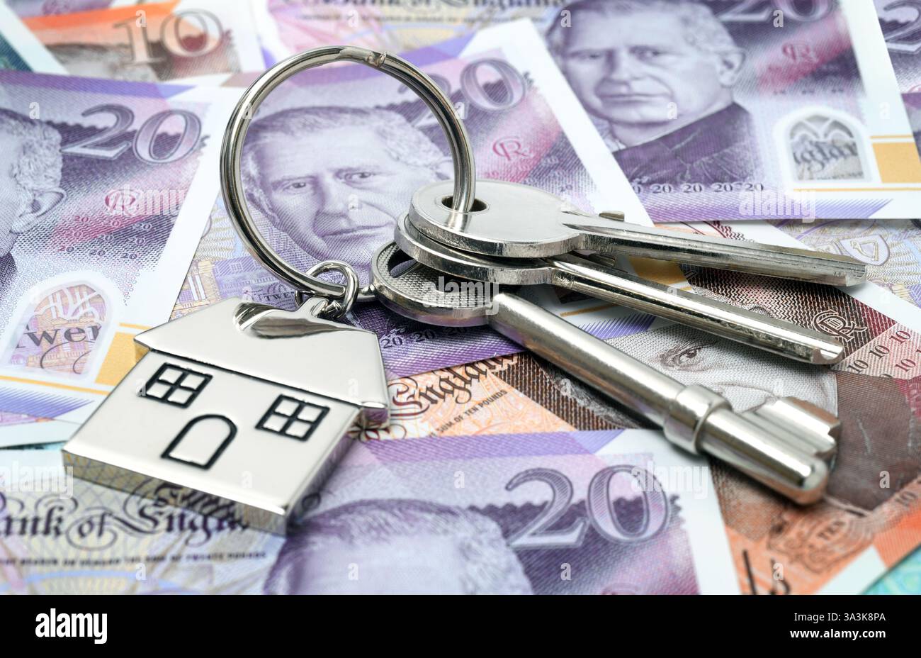 HAUSSCHLÜSSEL MIT HAUSSCHLÜSSELANHÄNGER UND BANKNOTEN RE HYPOTHEKEN EINLAGEN HAUSKÄUFER HAUSVERKÄUFE KREDITE USW. GROSSBRITANNIEN Stockfoto