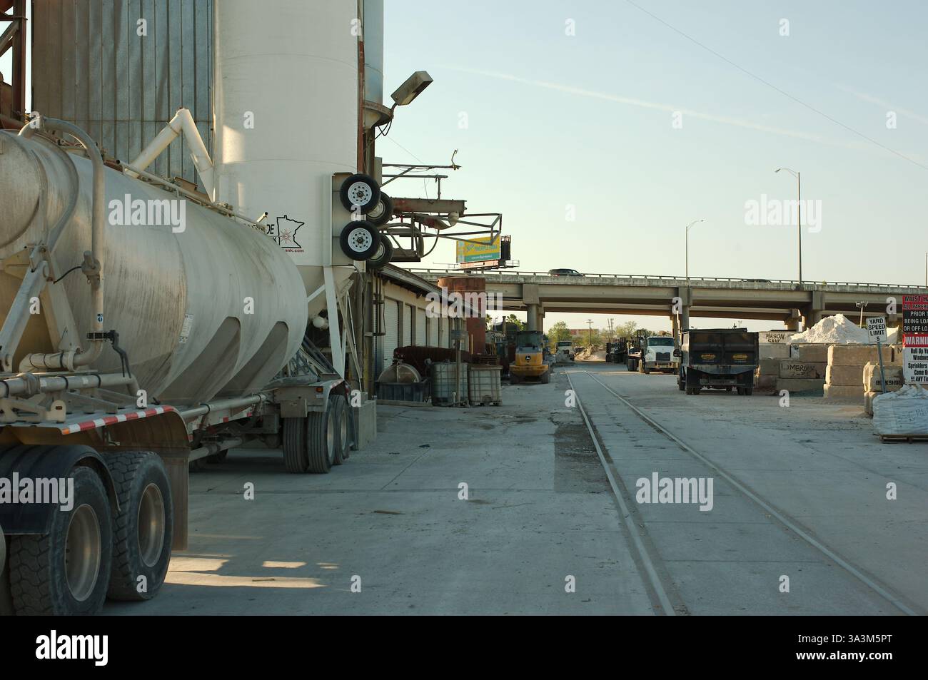 Industrieanlagen für Betonanlagen und Baustoffversorgung. Großer Zementwagen im Vordergrund. Einen hohen Aufbewahrungsbehälter zu verdecken. Hinten Stockfoto