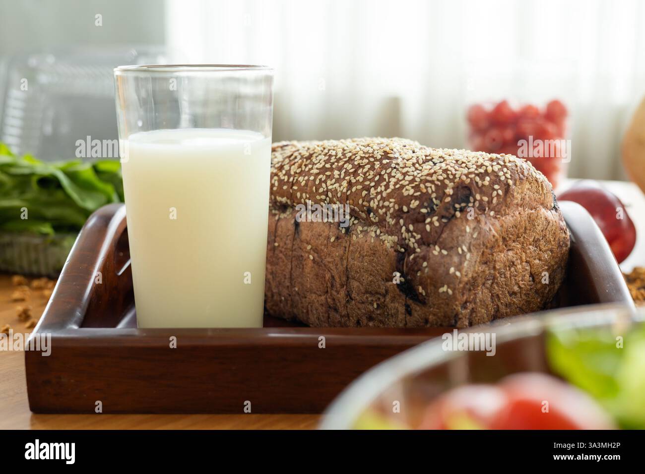 Eine einfache Mahlzeit mit Milch, Brot und einem geschnittenen Apfel. Perfekt für einen schnellen, einfachen und gesunden Start in den Tag. Stockfoto