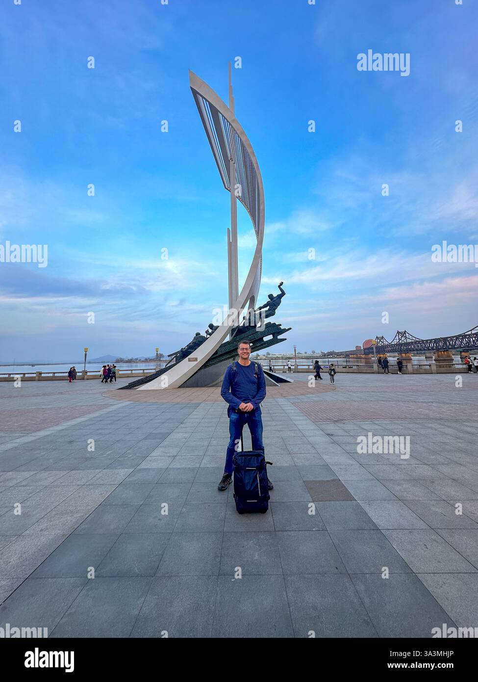 Ein Tourist steht neben einem Denkmal am Fluss Yalu. Dandong bildet einen umstrittenen östlichen Endpunkt der Ming Chinesischen Mauer. 14.4.2024, Liaoning, China. Stockfoto