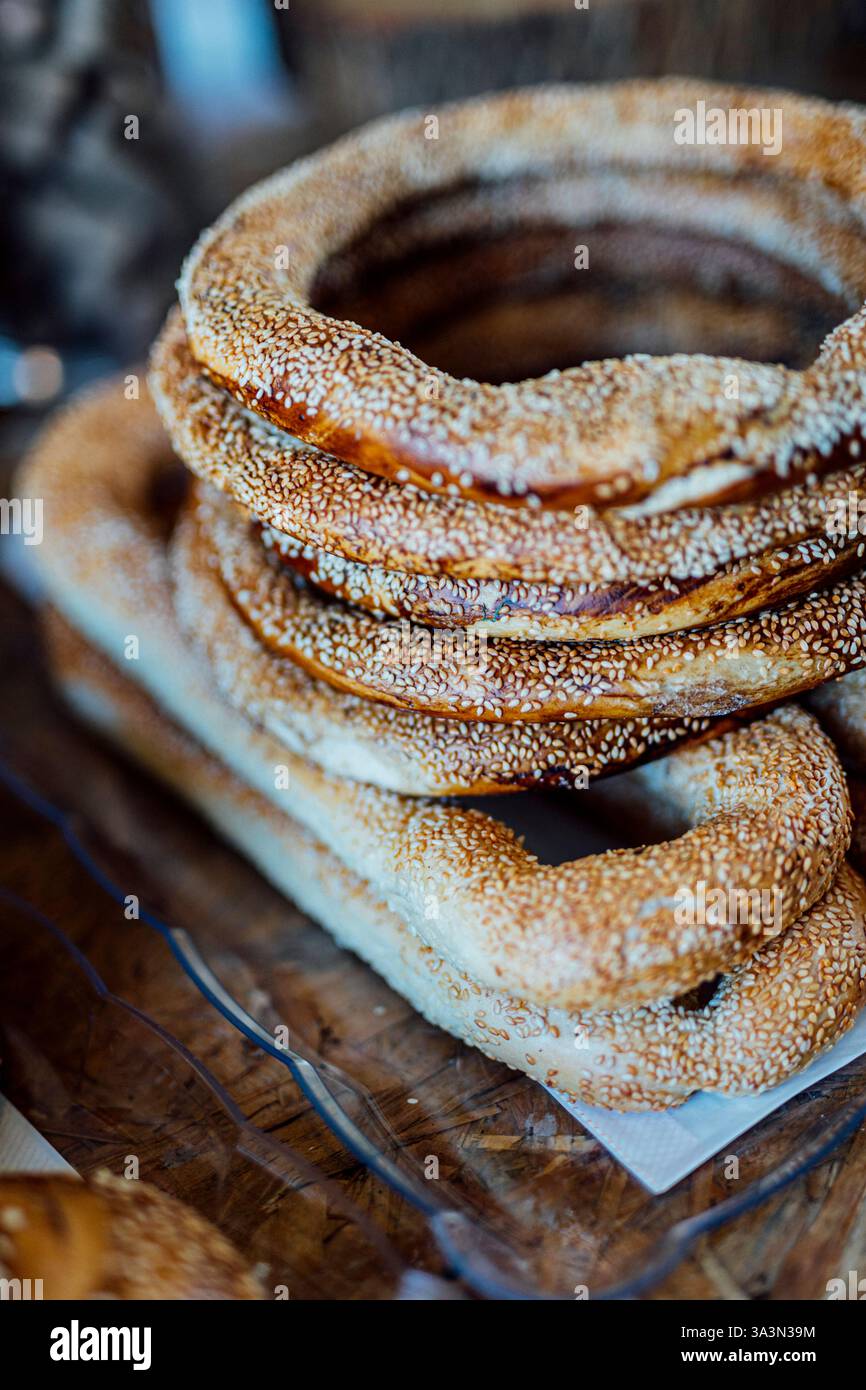 Eine Nahaufnahme frisch gebackener Sesambagels, die in einem traditionellen Korb angeordnet sind. Die goldbraune Kruste ist großzügig mit Sesamsamen bestreut, c Stockfoto