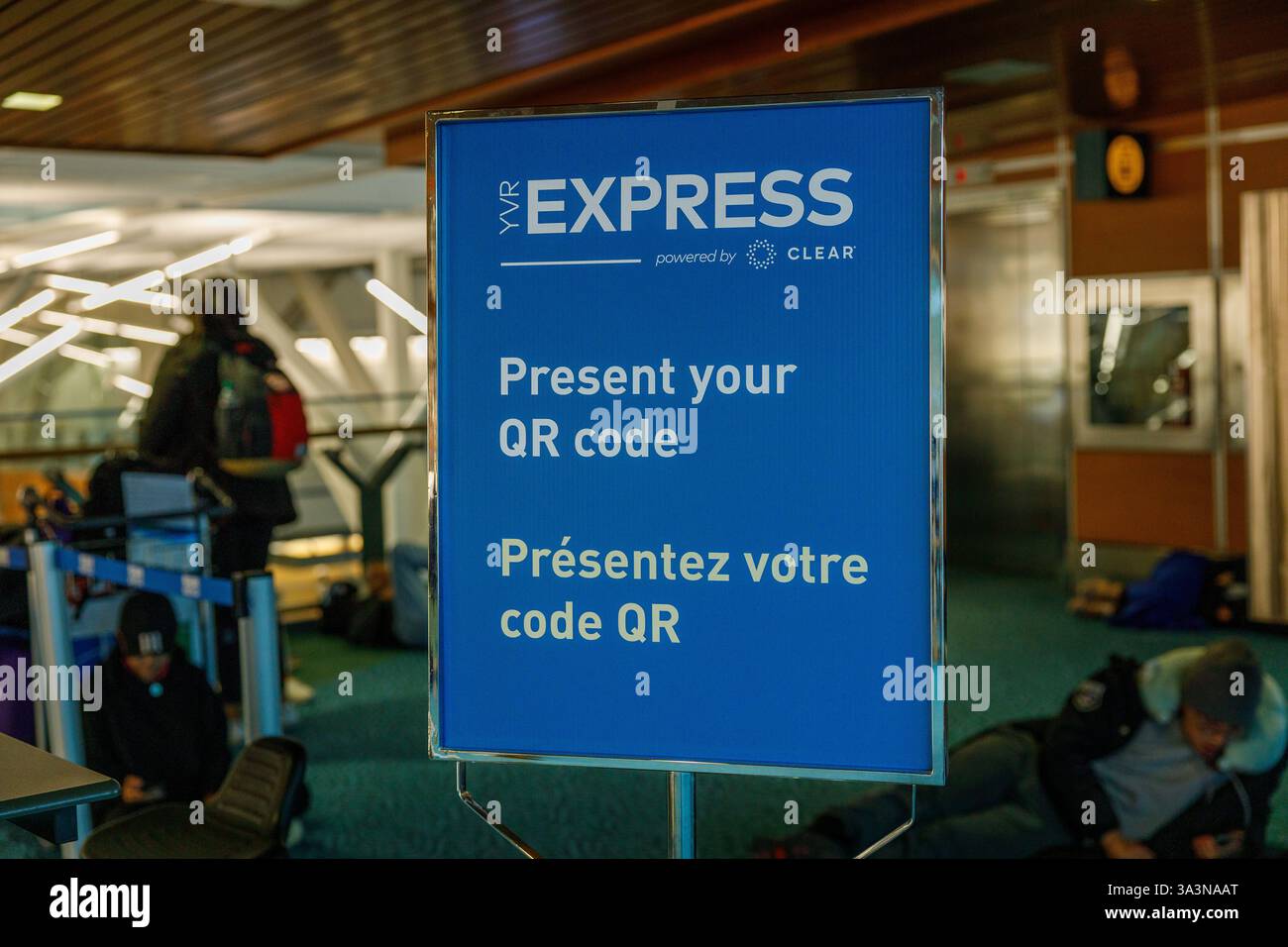 Vancouver, Kanada - 20. Dezember 2022: Blaues Schild am YVR-Flughafen mit der Aufschrift „YVR EXPRESS powered by CLEAR“ mit der Anweisung „Present your QR Code“ in E Stockfoto