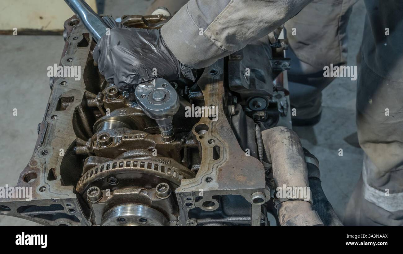 Automechaniker arbeitet am Automotor in der Mechanikerwerkstatt. Reparaturservice. Professioneller Mechaniker, der in der Garage am Motor des Autos arbeitet. Autoreparatur Stockfoto