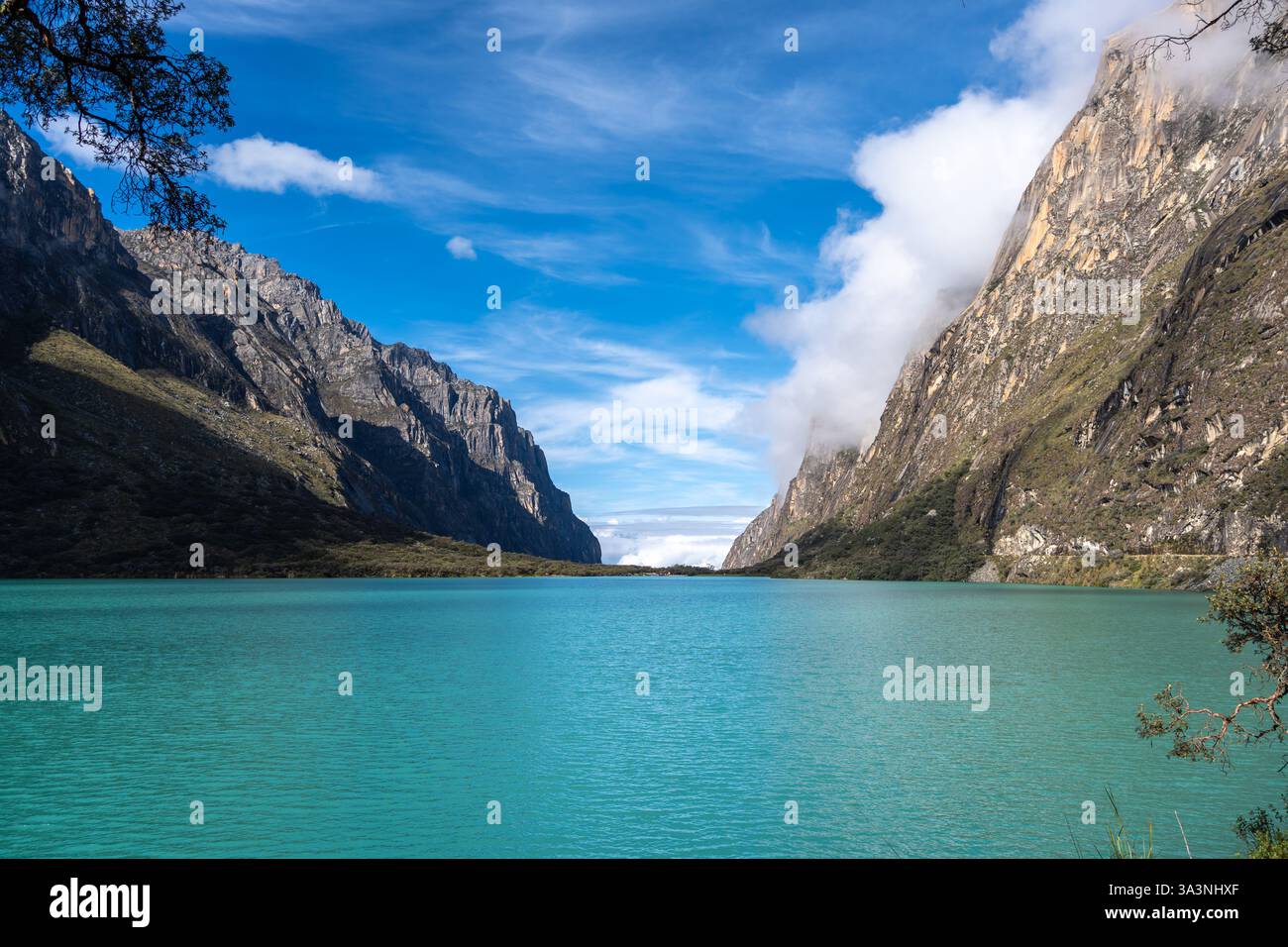 Ein atemberaubender türkisfarbener See reflektiert den blauen Himmel, eingebettet zwischen hoch aufragenden Bergen. Die friedliche Landschaft ist Teil der berühmten Laguna 69 Trek in Hu Stockfoto