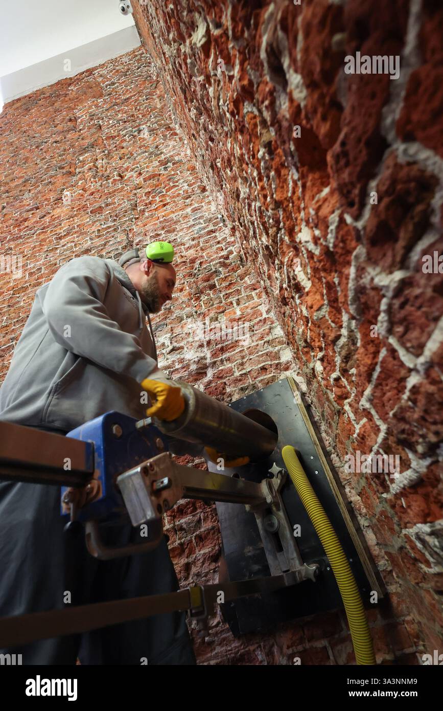 Hamburg, Deutschland. März 2025. Zwei Spezialisten eines Kernbohrunternehmens halten bei einer Presseveranstaltung den Bohrkopf mit Bohrkern im St. Michael-Turm. Der Turm der Hamburger Hauptkirche St. Michael weist tiefe Risse auf und die Renovierungsarbeiten sollen im Sommer beginnen. Quelle: Christian Charisius/dpa/Alamy Live News Stockfoto