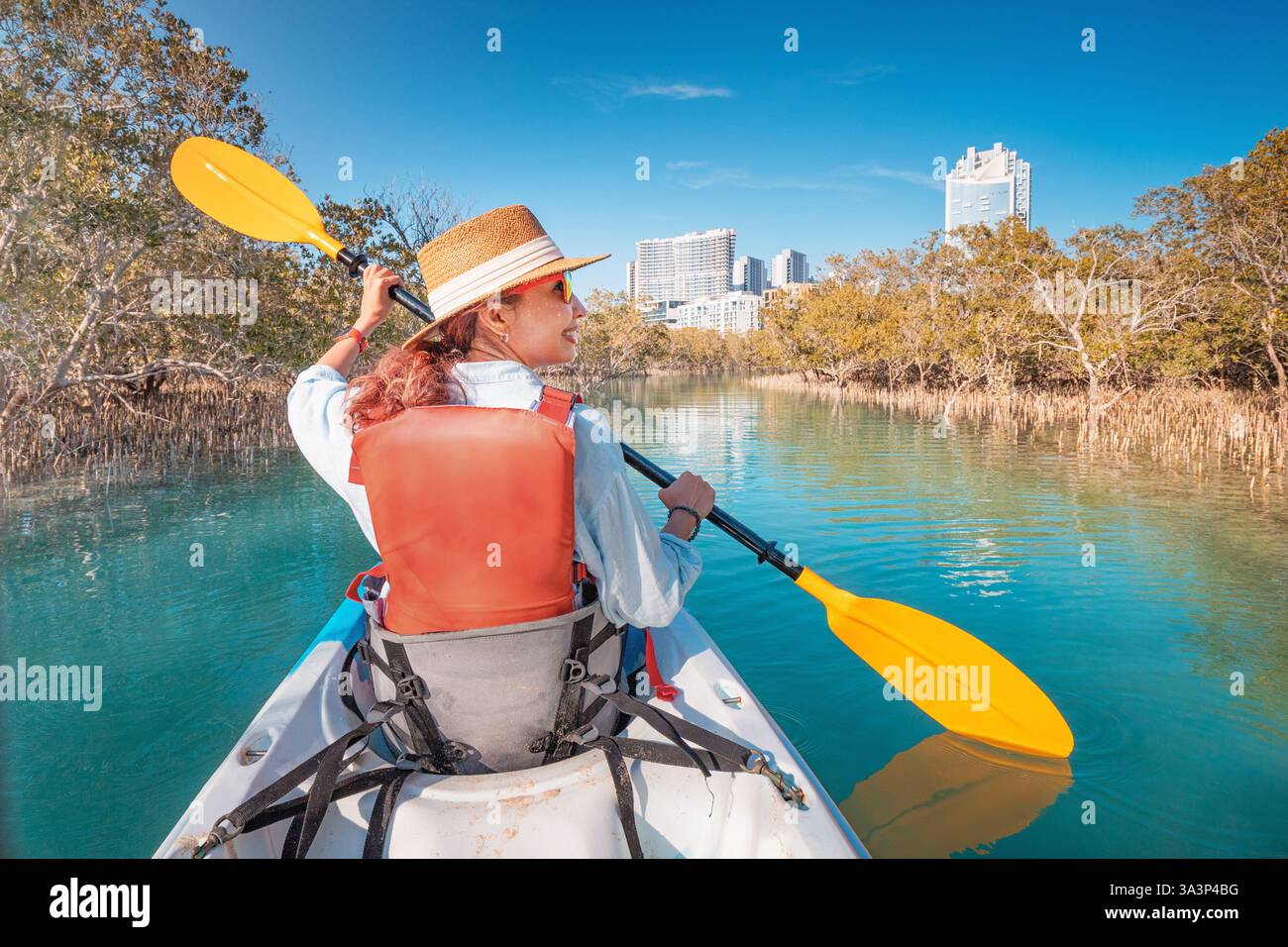 Frau paddelt im Kajak und erkundet den Mangrovenpark in Abu Dhabi, Vereinigte Arabische Emirate Stockfoto