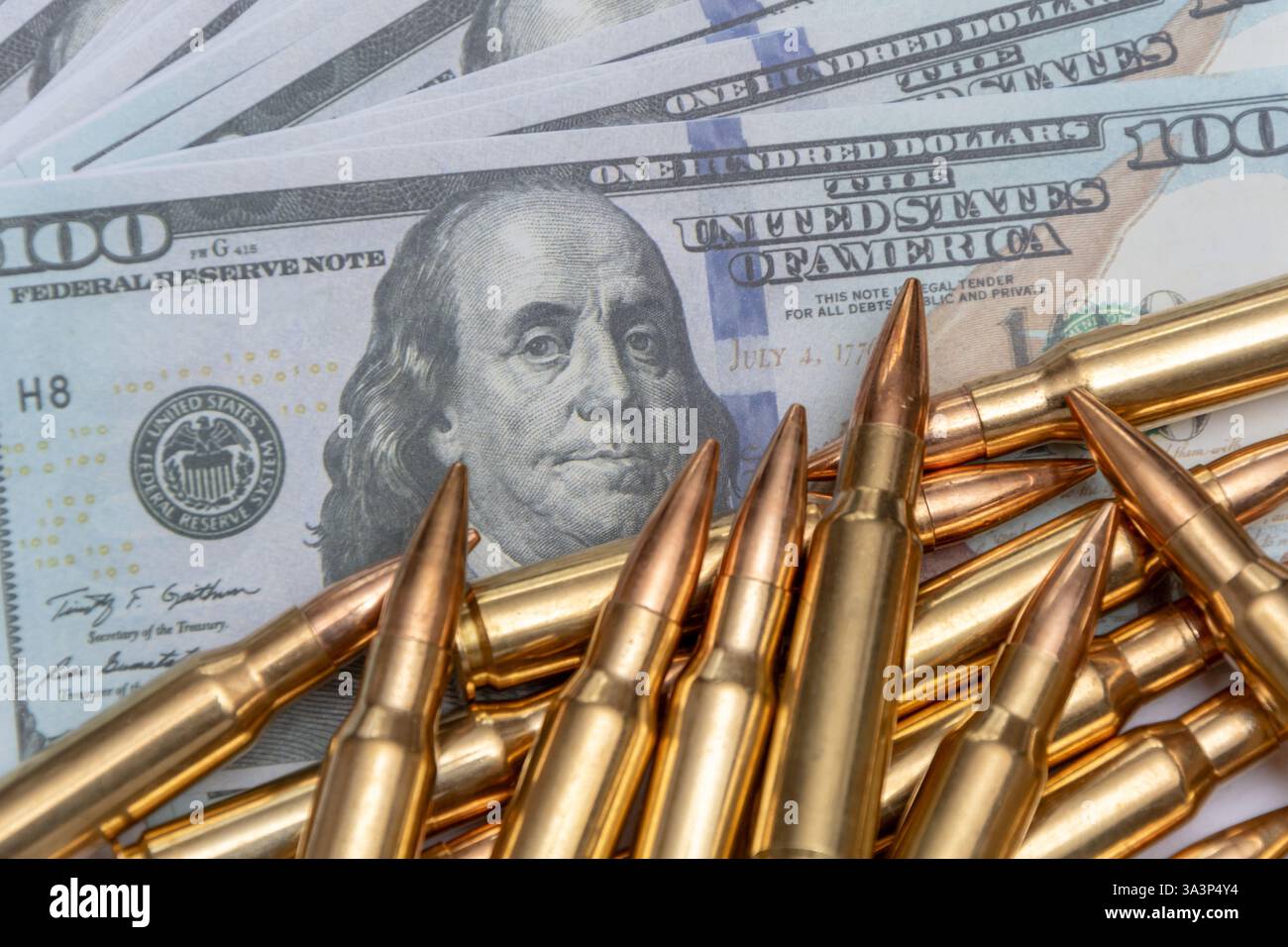 Munition vor dem Hintergrund von US-Banknoten, ein Spiegelbild des Zusammenhangs zwischen Waffen und Finanzen. Язык ключевых с Stockfoto