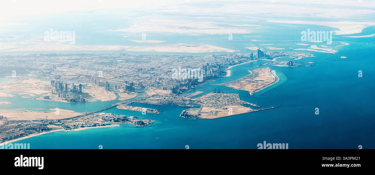 Atemberaubende Aussicht auf Abu Dhabi aus der Vogelperspektive mit modernen Wolkenkratzern, türkisfarbenem Meer und riesiger Wüstenlandschaft, die einen fesselnden Kontrast schaffen Stockfoto